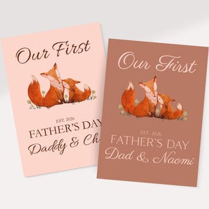 Könnte beinhalten: Zwei rechteckige Grußkarten mit einer Aquarellillustration von zwei Füchsen. Die linke Karte ist hellrosa, die rechte terrakottafarben. Beide zeigen den Text Our First FATHER'S DAY EST. 2026 sowie personalisierte Namen am unteren Rand.