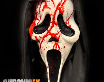 May include: A white Scream mask with black eye and mouth openings, splattered with red paint to resemble blood. The mask is set against a black background and has a black hood. The text "CHRONICFX" is at the bottom.