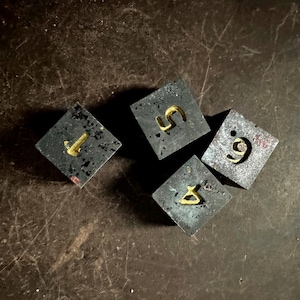 May include: Four gray concrete blocks with gold numbers 1, 5, 6, and 9 on them.