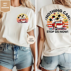 a woman wearing a t - shirt with mickey mouse driving a car