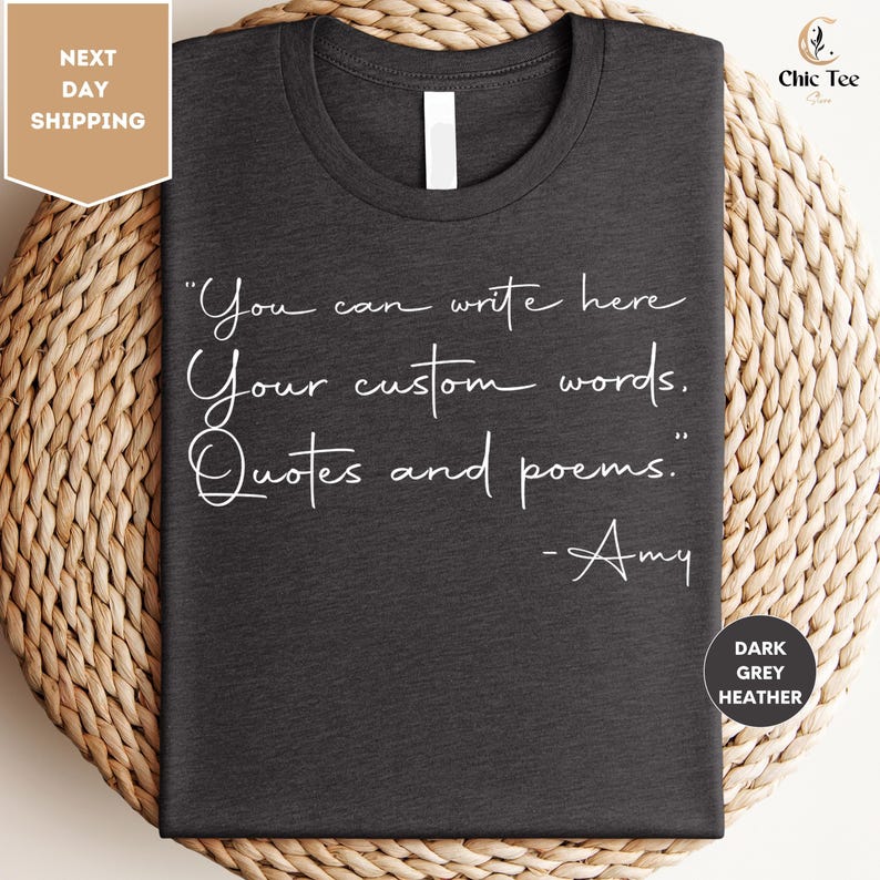 a gray t-shirt with a quote printed on it, placed on a woven mat.