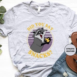 a shirt with a raccoon saying did you say snacks?