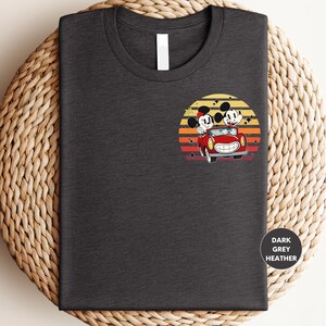 a t - shirt with mickey and minnie driving a car