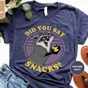 a shirt with a raccoon saying did you say snacks?