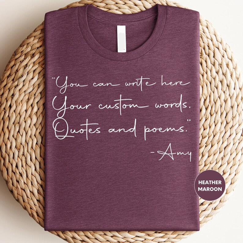 a purple t-shirt with a quote printed on it, placed on a woven mat.