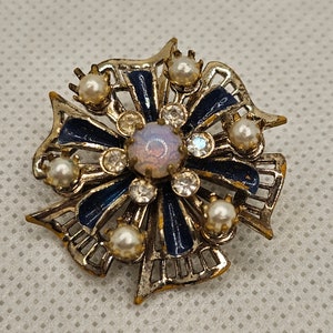 Gold Toned Vintage Brooch With Blue Enamel, Glass Pearls, and Rinestones with a Milky white stone in the middle