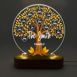 Może przedstawiać: Spersonalizowana lampka nocna z drzewem genealogicznym. Projekt drzewa przedstawia brązowy pień i żółte liście z imionami w ramkach w kształcie serca. Podstawa jest z ciemnego drewna, a tekst brzmi "The Smith Family."