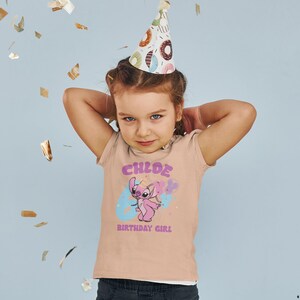 K&ouml;nnte beinhalten: Ein hellrosa T-Shirt mit einer blauen und pinkfarbenen Comicfigur, die einen Ballon h&auml;lt. Das Shirt tr&auml;gt den Schriftzug "CHLOE 6 BIRTHDAY GIRL" in einer bunten Schrift.