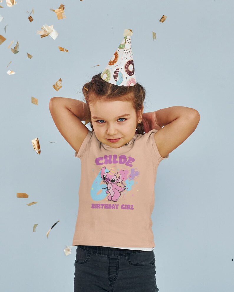 K&ouml;nnte beinhalten: Ein hellrosa T-Shirt mit einer blauen und pinkfarbenen Comicfigur, die einen Ballon h&auml;lt. Das Shirt tr&auml;gt den Schriftzug "CHLOE 6 BIRTHDAY GIRL" in einer bunten Schrift.