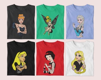 May include: Six t-shirts in various colors, each featuring a cartoon princess with tattoos. The shirts include Cinderella in black, Tinkerbell in green, Elsa in light blue, Alice in black, Snow White in red, and Rapunzel in white.