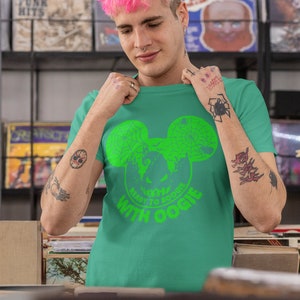 May include: A green t-shirt with a green Mickey Mouse head graphic. The graphic has a spider web design and the text "Ready to Boogie with Oogie".