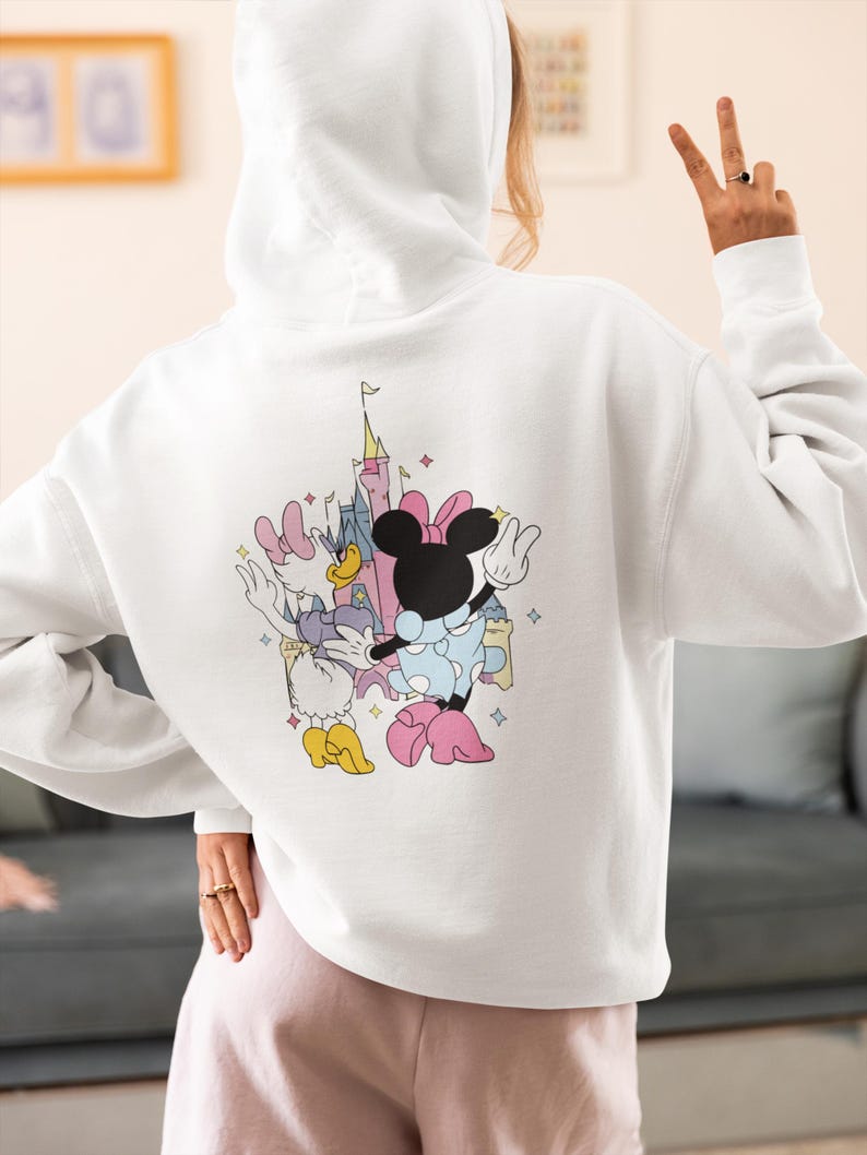 May include: White hooded sweatshirt with a graphic print of Mickey Mouse and Minnie Mouse in front of Cinderella's Castle.