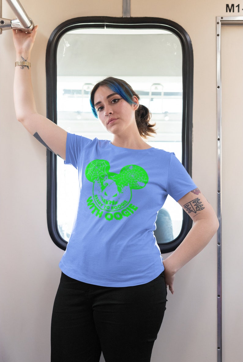 May include: A light blue t-shirt with a green graphic of a cartoon face with Mickey Mouse ears. The graphic includes the text "Ready to Boogie with Oogie".