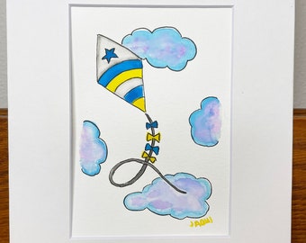 May include: A watercolor painting of a kite flying in a blue sky with white clouds. The kite is yellow, blue, and white with a star on it. The string of the kite is decorated with yellow bows. The painting is signed "Jami" in the bottom right corner.