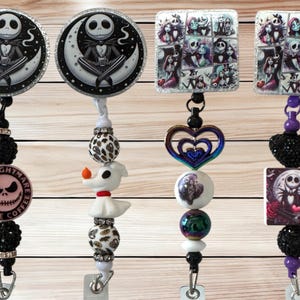 May include: A collection of retractable badge reels featuring designs from The Nightmare Before Christmas. The reels showcase Jack Skellington, Zero, and other characters. Each reel has decorative beads and a clip for attaching to clothing.
