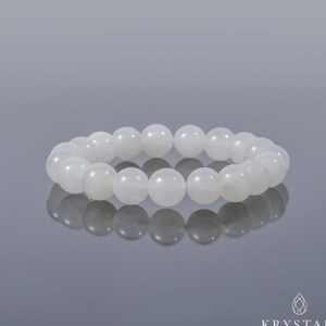May include: White gemstone bracelet with round beads. The bracelet is made of natural stones and is designed to be worn on the wrist.