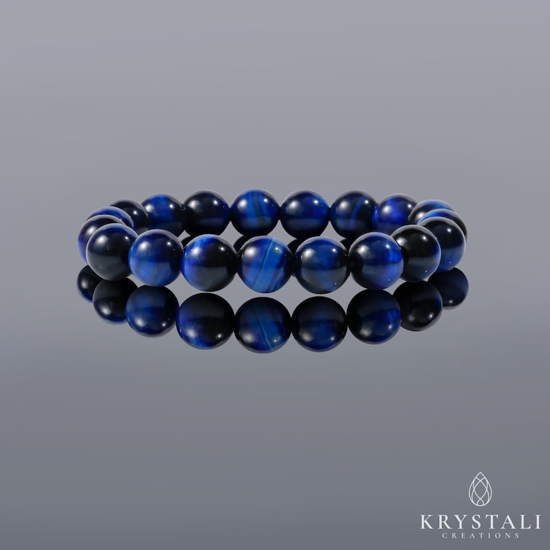May include: A blue tiger's eye gemstone bracelet with round beads. The bracelet is made of natural stones and is a popular choice for jewelry.
