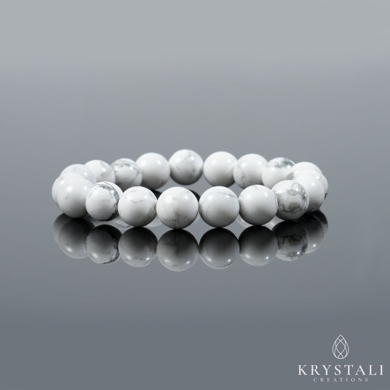 May include: White Howlite beaded bracelet. The bracelet is made of round, smooth beads and is approximately 7 inches in length.