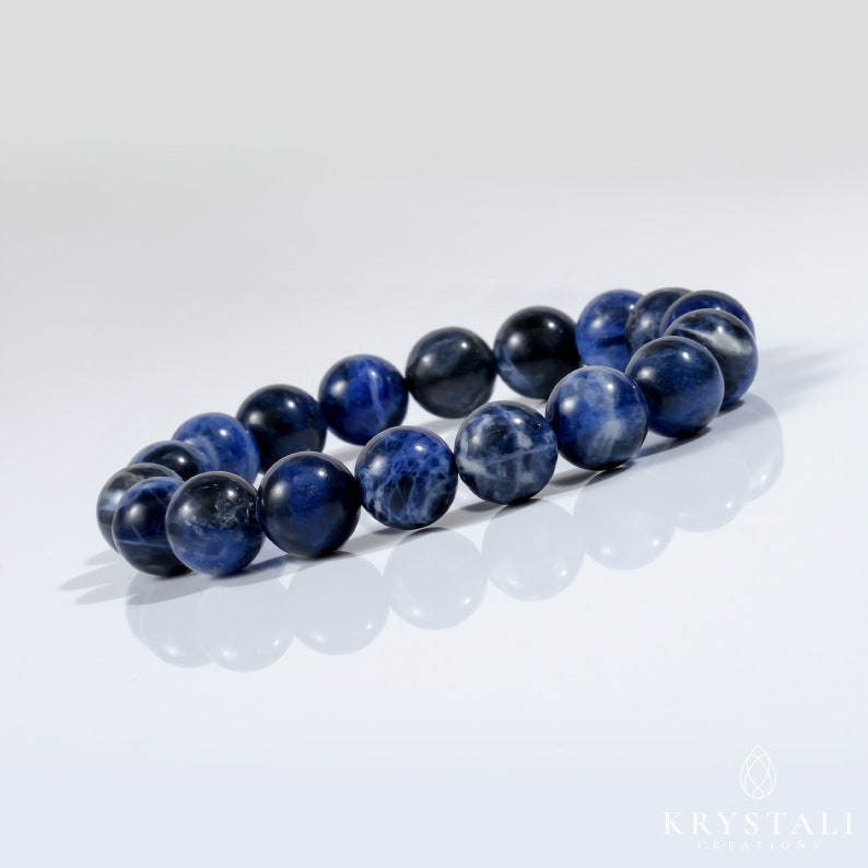 Op de afbeelding: Een blauwe edelsteen armband gemaakt van ronde kralen. De armband is gemaakt van een lichtblauwe en donkerblauwe steen.