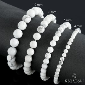 May include: Four white Howlite bead bracelets in different sizes: 4 mm, 6 mm, 8 mm, and 10 mm. The bracelets are arranged in a row on a black surface.