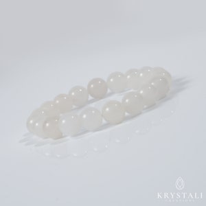 May include: A white gemstone bracelet with round beads. The bracelet is made of natural white stones and is designed to be worn on the wrist.