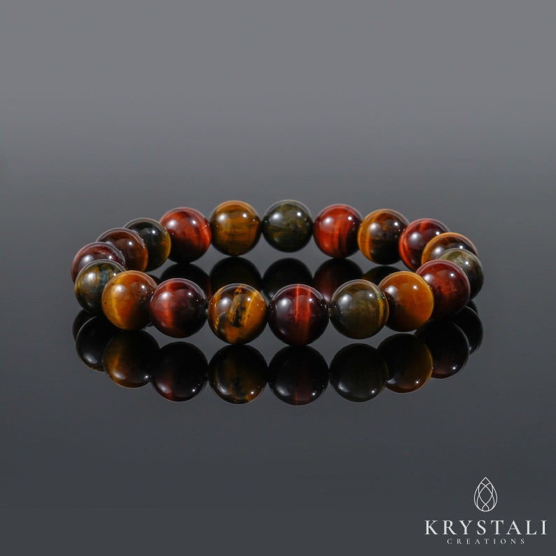 May include: A bracelet made of tiger's eye beads in shades of red, gold, and green. The beads are round and polished, and the bracelet is strung on elastic.