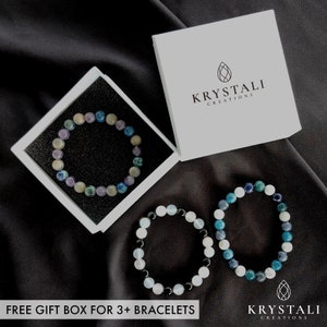 May include: Three gemstone bracelets in a white box. The bracelets are made of blue, green, and white stones. The box has the text "Krystali Creations" on it. Free gift box for 3+ bracelets.