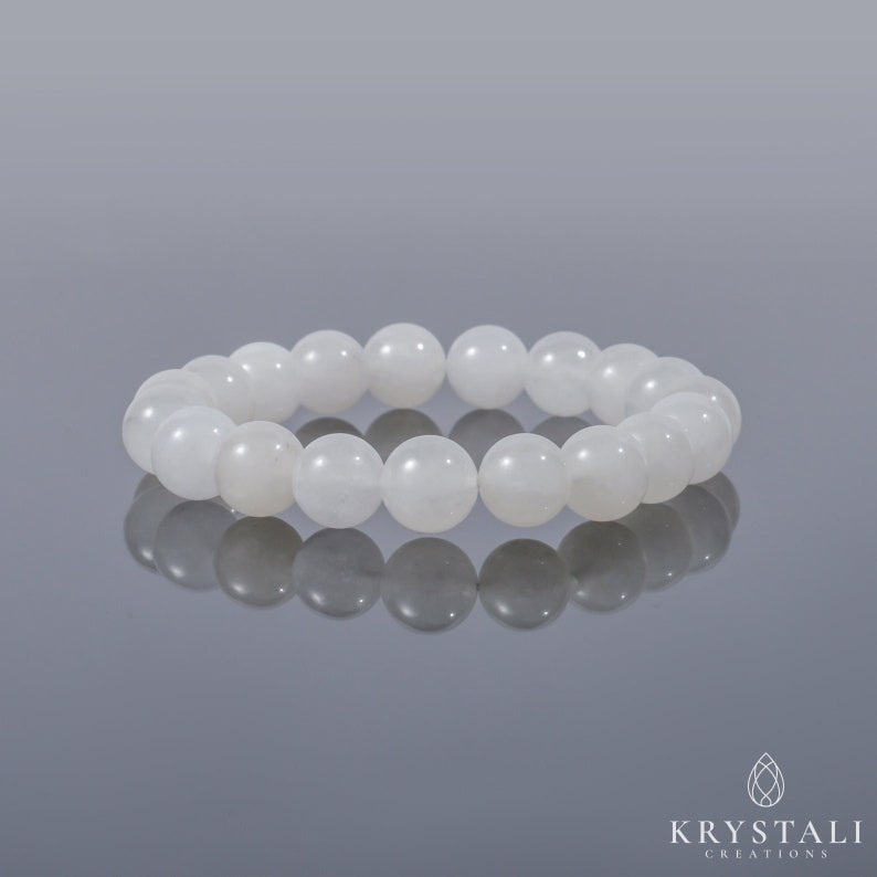 May include: White gemstone bracelet with round beads. The bracelet is made of natural stones and is designed to be worn on the wrist.