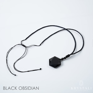 K&ouml;nnte beinhalten: Eine Halskette mit einem Anh&auml;nger aus schwarzem Obsidian. Der Anh&auml;nger hat eine facettierte, geometrische Form und h&auml;ngt an einer schwarzen Kordel. Die Kordel ist mit Schiebeknoten verstellbar. Der Text "BLACK OBSIDIAN" befindet sich unten im Bild.