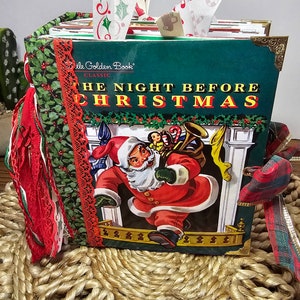 Może przedstawiać: Antyczna książka Little Golden Book zatytułowana "Noc przed Bożym Narodzeniem" z zieloną okładką i obrazkiem Świętego Mikołaja niosącego worek z zabawkami. Książka jest ozdobiona czerwoną i zieloną wstążką, koronką i resztkami tkaniny.