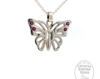 May include: Silver butterfly pendant necklace with two small pink gemstones on each wing.