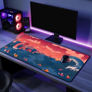 May include: A rectangular mouse mat with a colourful illustration of a dragon in ocean waves under a sunset. The design features orange, red, and blue tones. A black mouse is positioned on the mat.