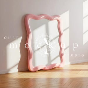Könnte beinhalten: Ein großer, wellenförmiger rosa Rahmen lehnt an einer weißen Wand auf einem Holzboden. Der Rahmen hat eine glänzende Oberfläche und eine einzigartige, organische Form. Der Text "QUEEN MOCKUP STUDIO" ist auf dem Rahmen aufgedruckt.