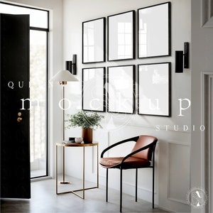 Puede incluir: Una pared blanca con seis cuadros negros enmarcados, una silla de cuero marrón, una mesa auxiliar de metal dorado, una lámpara de pie y una puerta negra.