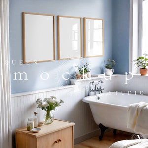 May include: A white bathtub with a chrome faucet and a white towel on the edge. The bathroom has white wainscoting and a light blue wall with three framed pictures.