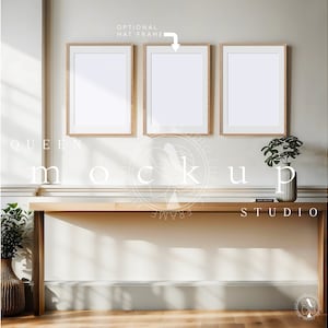 May include: Three empty picture frames with a light wood finish are hanging on a white wall above a wooden console table. The table has a light wood finish and is sitting on a light wood floor. A small potted plant is sitting on the table.