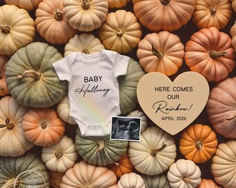 May include: A collection of pumpkins in various colors surrounds a white baby onesie with the name "Halloway" and a rainbow design. A heart-shaped sign reads "Here Comes Our Rainbow! April 2026" and an ultrasound image.