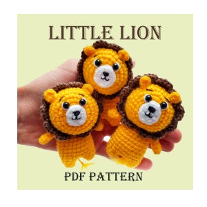 May include: Three crocheted lion plushies in a hand. The lions are yellow with brown manes and black eyes. The text "LITTLE LION" and "PDF PATTERN" are visible in the image.