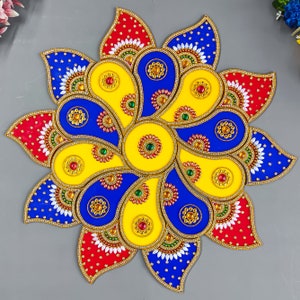 May include: A colourful paper mandala with a yellow centre and blue and red petals. The mandala is decorated with gold glitter and small gems.