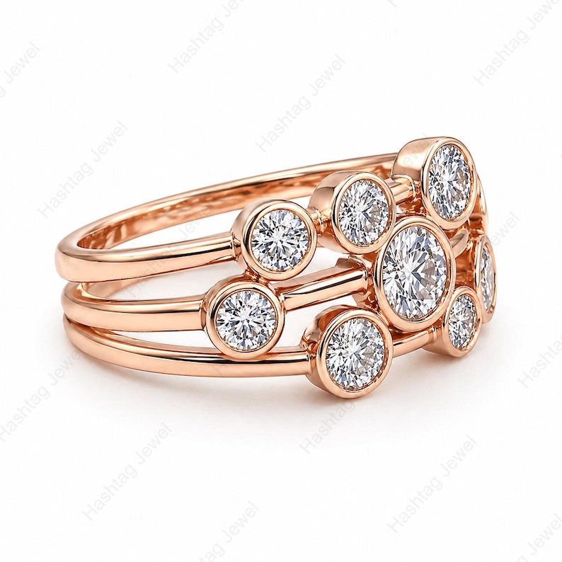 May include: Rose gold ring featuring multiple round, bezel-set diamonds. The ring has three bands with diamonds arranged in a cluster design. The diamonds sparkle against the warm metal.