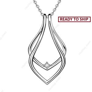 Puede incluir: Un collar con colgante plateado con un diseño de lágrima. El colgante presenta un pequeño diamante redondo en el centro y está suspendido de una delicada cadena. Las palabras "READY TO SHIP" están en un recuadro rojo.