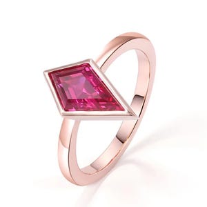 Op de afbeelding: Een ring van roségoud met een roze edelsteen in een diamantvormige zetting.