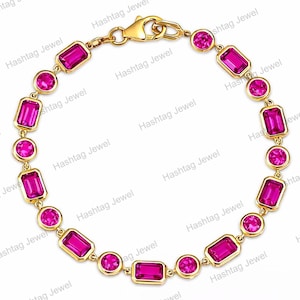 May include: A gold chain bracelet featuring alternating round and emerald-cut vibrant pink gemstones set in polished gold bezels. The bracelet is secured with a gold lobster claw clasp, creating a continuous circular design of bright pink stones.