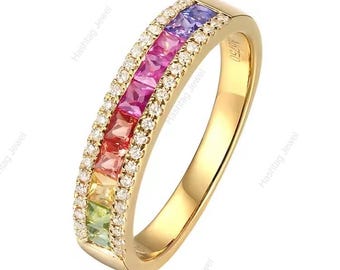 May include: A gold band ring featuring a central row of square-cut rainbow-colored gemstones, including purple, pink, red, orange, yellow, and green, flanked by two rows of small round white diamonds. The inner band is stamped with the text Au750.