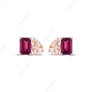 Puede incluir: Un par de pendientes con una gema rectangular de color rojo intenso y una gema en forma de pera de color melocotón claro. Los pendientes están engastados en metal de oro rosa.