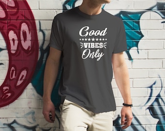 May include: A dark gray t-shirt with white text that reads "Good Vibes Only" with a row of stars above the word "Vibes".