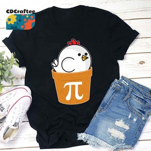 May include: A black t-shirt with a white chicken in a brown pot with a pi symbol on it.
