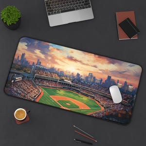 Puede incluir: Una vista panorámica de un estadio de béisbol con una ciudad en el fondo. El estadio está lleno de gente y el campo es verde con un cuadro interior marrón. El cielo es de un naranja y rosa vibrante con nubes.