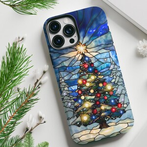 May include: A smartphone case featuring a stained glass style design of a Christmas tree with glowing red, yellow, and blue ornaments. The background consists of blue and white geometric glass patterns with a bright star at the tree top.