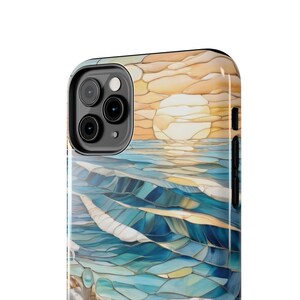 May include: A smartphone case featuring a stained glass style design of a sunset over the ocean. The image displays a bright yellow sun above blue and teal waves, with a segmented, mosaic-like pattern covering the entire back of the device case.